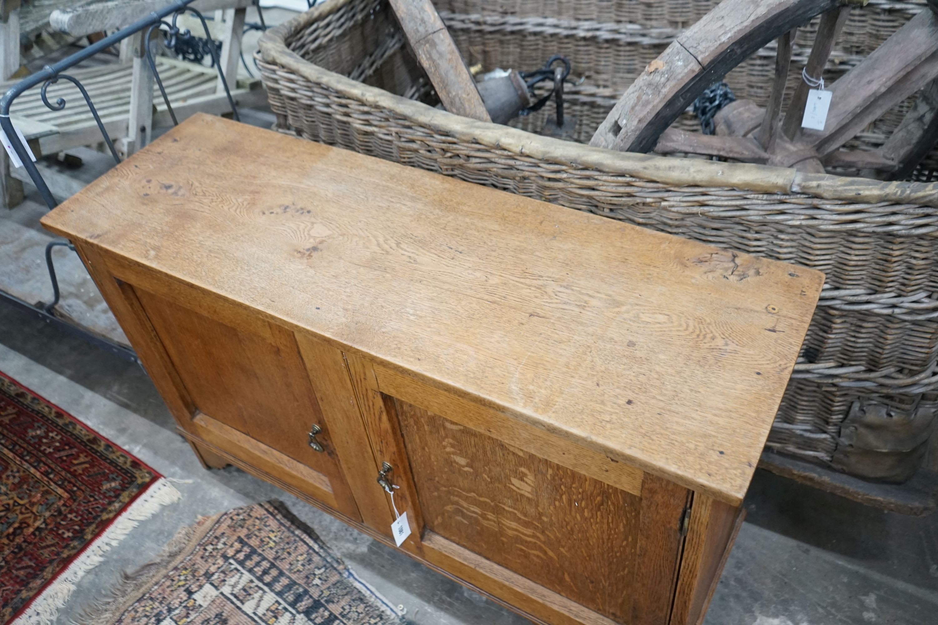 A 1920's two door oak low cabinet, width 120cm, depth 39cm, height 76cm